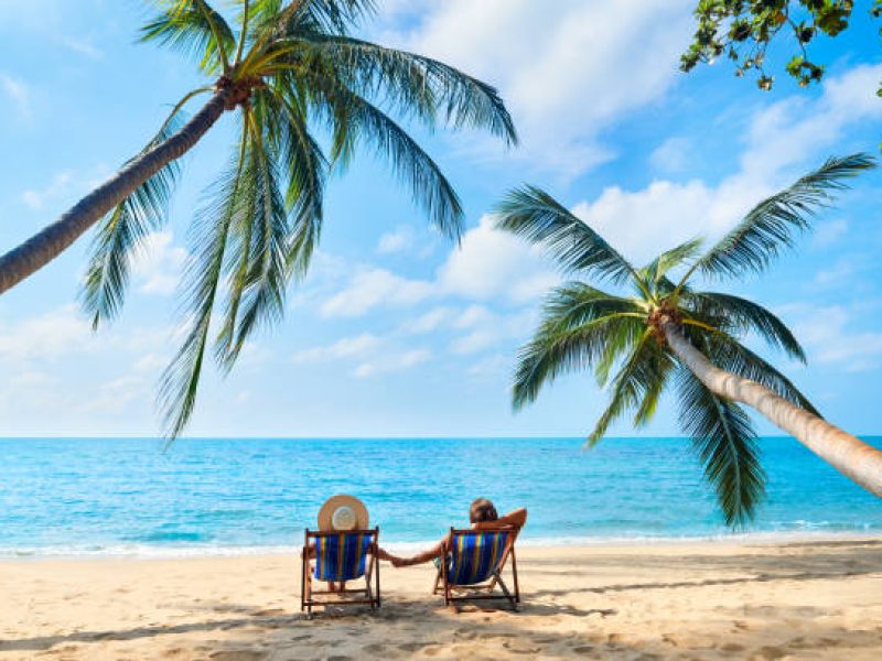 Couple relax on the beach enjoying beautiful sea on the tropical island. Summer beach vacation concept